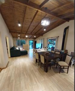 a dining room and living room with a table and chairs at Encanto serrano in Sierra de los Padres