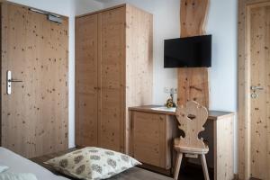 a bedroom with a bed and a sink and a chair at Der Brunnerhof in Mühlbach