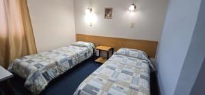 a room with two beds and a table in it at Hotel Oviedo in Río Gallegos