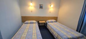 a room with two beds and a table in it at Hotel Oviedo in Río Gallegos