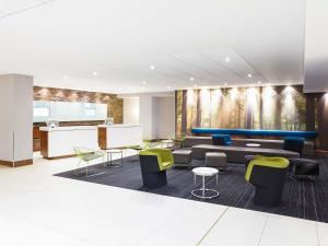 a lobby with a couch and chairs and tables at Novotel London West in London