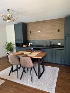 a kitchen with a wooden table and some chairs at Cabana Forest in Borşa