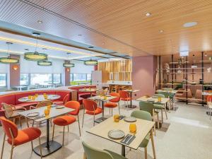 a restaurant with tables and chairs in a room at Novotel Lisboa in Lisbon