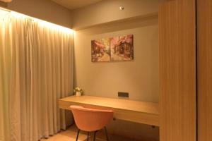 a desk in a room with a chair and a painting at The Signature Suite in Raipur