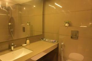 a bathroom with a sink and a mirror at The Signature Suite in Raipur +5 photos