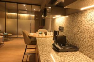 a kitchen with a counter with a table and chairs at The Signature Suite in Raipur