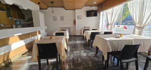 a restaurant with tables and chairs in a room at Hotel Oviedo in Río Gallegos