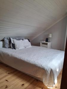 a bed with white sheets and pillows in a bedroom at Villa Aili in Pärnu