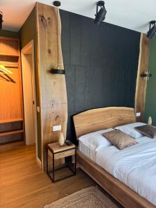 a bedroom with a bed with a wooden headboard at Cabana Forest in Borşa +3 photos