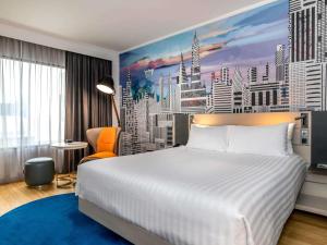 a bedroom with a large bed and a city mural at Novotel Bangkok on Siam Square in Bangkok