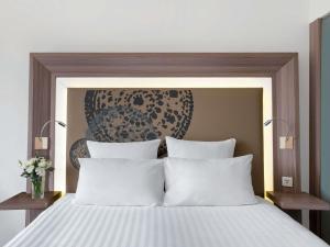 a bedroom with a large bed with two pillows at Novotel Bangkok on Siam Square in Bangkok