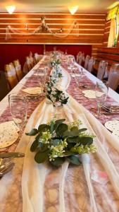a long table with wine glasses and flowers on it at Horská chata Hubert in Bedřichov
