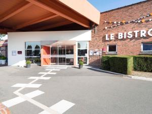 a store front of a brick building with a entrance at Hôtel Mercure Lille Aéroport in Lesquin