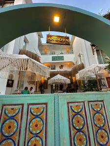 an archway over a building with tables and umbrellas at Andoya Butik Pansiyon in Bodrum City