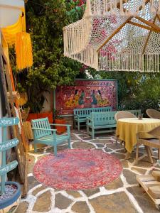 a patio with benches and a table and a rug at Andoya Butik Pansiyon in Bodrum City