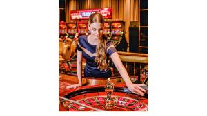 a woman standing at a roulette table in a casino at VIP In Alliance Palace in Batumi