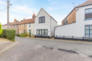 an empty street in front of a white house at 2 Bed in Holt oc-2231 in Holt
