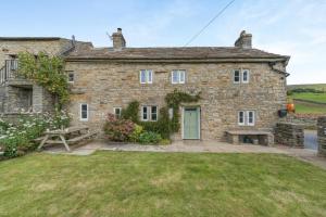 an old stone house with a picnic table in front of it at 3 Bed in Askrigg oc-ds926 in Askrigg