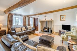 a living room with a leather couch and a fireplace at 3 Bed in Askrigg oc-ds926 in Askrigg