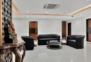 a lobby with black leather chairs and a table at Super Hotel O Rudra Grand in Hyderabad
