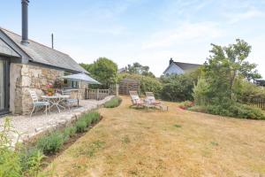 a yard with a table and chairs and a house at 1 Bed in Penzance oc-78517 in Newlyn
