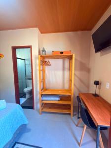 ein Schlafzimmer mit einem Bett, einem Schreibtisch und einem Spiegel in der Unterkunft Casa Sol da Ilha in Angra dos Reis + 28 Fotos