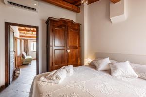 a bedroom with a bed with white sheets and a wooden cabinet at Come Una Volta Apricale antica dimora ligure - Parcheggio a pochi metri in Apricale