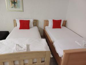 two beds in a room with white and red pillows at Guest house in Datteln 2 & 3 in Datteln