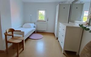 a small bedroom with a bed and a chair at Vacation apartment Stüble in Aichstetten