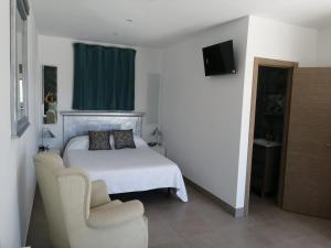 a bedroom with a bed and a chair at Finca Laxuan in Cádiz +24 photos