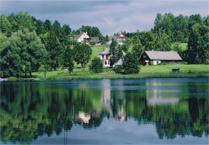 a house on a hill next to a lake at Rõuge Suurjärve Külalistemaja in Rõuge