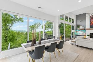 a dining room with a table and chairs and large windows at Casa del Sueño - Big Canoe, GA - Take a Dip in the Private Swim Spa, Rack Up a Game of Pool, and Stay Active in the In-Home Fitn in Afton