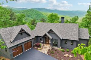 an aerial view of a house with mountains in the background at Casa del Sueño - Big Canoe, GA - Take a Dip in the Private Swim Spa, Rack Up a Game of Pool, and Stay Active in the In-Home Fitn in Afton