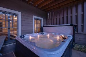 a jacuzzi tub sitting on a porch at K-Tees Cottage - Big Canoe,GA - Soak in the Private Hot Tub, Challenge Friends in the Arcade, Take in Scenic Golf Course Views, in Holcomb