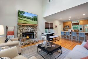 a living room with a fireplace and a kitchen at K-Tees Cottage - Big Canoe,GA - Soak in the Private Hot Tub, Challenge Friends in the Arcade, Take in Scenic Golf Course Views, in Holcomb