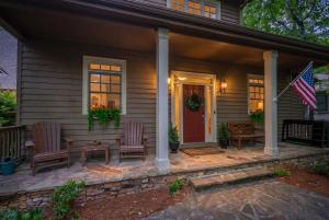 a porch with two chairs and an american flag at K-Tees Cottage - Big Canoe,GA - Soak in the Private Hot Tub, Challenge Friends in the Arcade, Take in Scenic Golf Course Views, in Holcomb