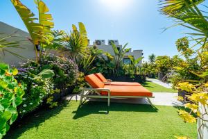 an orange chair sitting on the grass in a garden at VIVASTAY Casablanca -Corniche Le claridge Emerauld with gym and rooftop in Casablanca