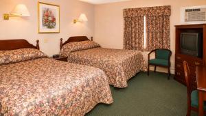 a hotel room with two beds and a television at Traveller's Inn Prince Edward Island in Summerside +35 photos
