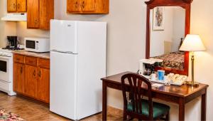 a kitchen with a white refrigerator and a wooden table at Traveller's Inn Prince Edward Island in Summerside