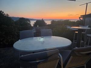 a table and chairs with a sunset in the background at Casa Maja in Karlobag