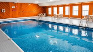 a swimming pool with blue water in a building at Traveller's Inn Prince Edward Island in Summerside