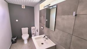 a bathroom with a white toilet and a sink at Przytulne studio  +3 photos