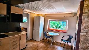 a kitchen with a table and two chairs and a window at Przytulne studio 