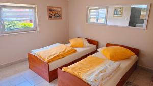two twin beds in a room with two windows at Przytulne studio 
