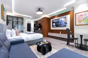 a living room with a bed and a table at FLORIA - Sky Suites in Accra