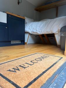 a welcome mat on the floor of a bedroom with a bunk bed at Oakwood Marina in Northwich