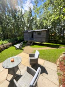 a patio with a table and chairs and a cabin at Oakwood Marina in Northwich