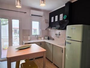 a kitchen with a refrigerator and a table in it at Kalamea Apartment Kalathas in Kalathas