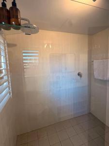 a bathroom with a shower with white tiles at 22 Emoyeni Drive in Hillcrest