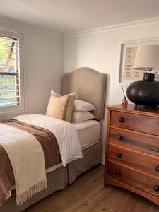 a bedroom with a bed and a dresser with a lamp at 22 Emoyeni Drive in Hillcrest